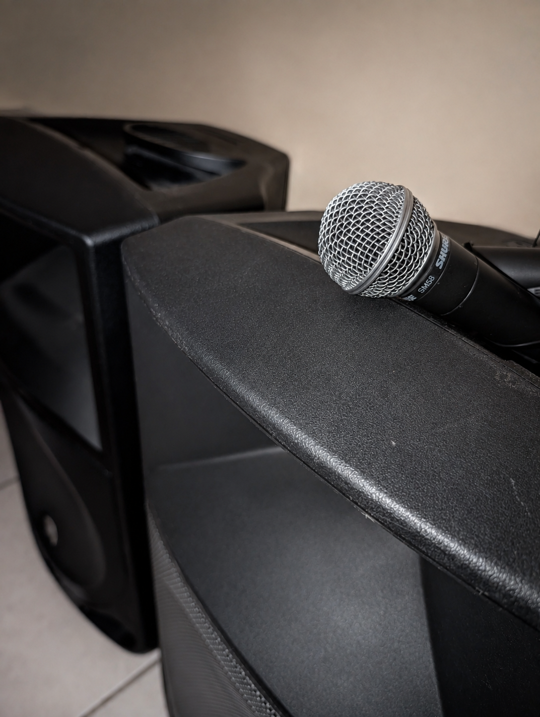 Classic Shure SM58 microphone resting on an active PA loudspeaker